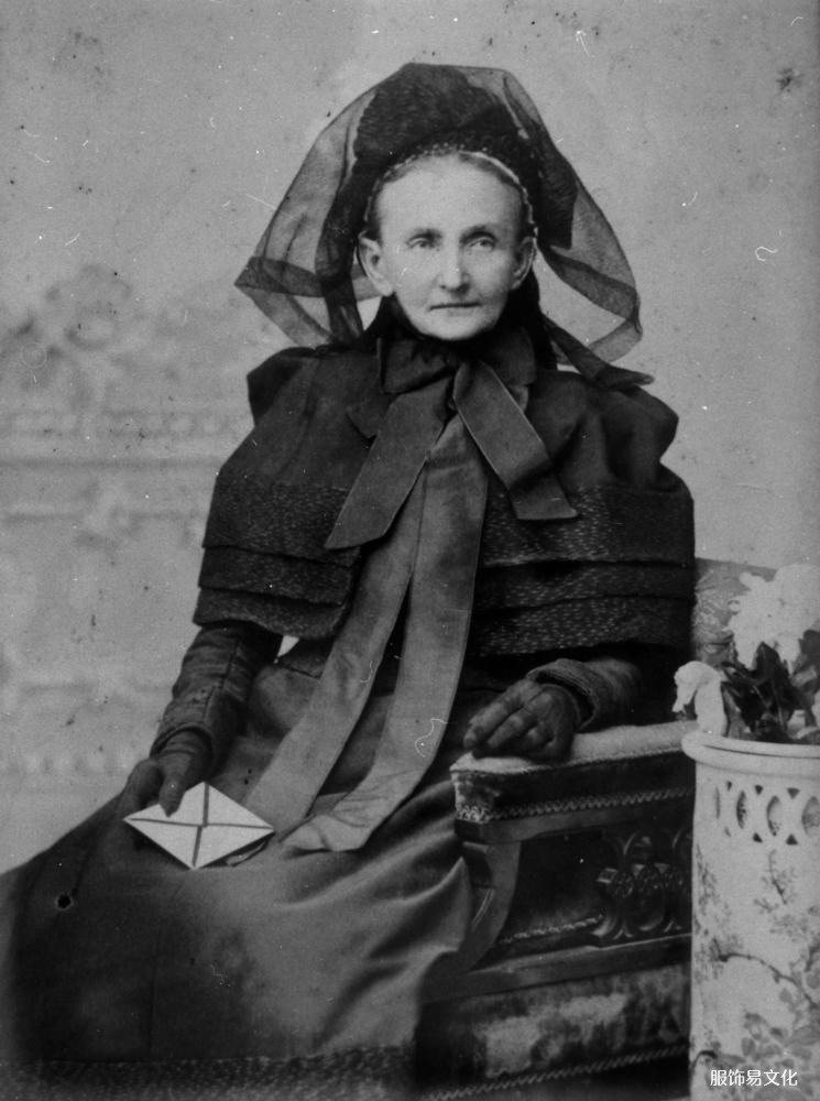StateLibQld_1_130771_Elderly_woman_possously_dressed_in_mourning_clothes_1890-1900.jpg